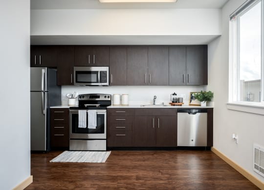 The Waterline Everett, WA Kitchen Studio with dark cabinets and stainless steel appliances