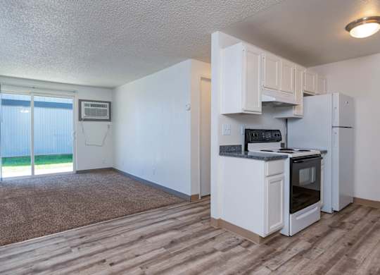 A kitchen with white appliances and a microwave on the counter.