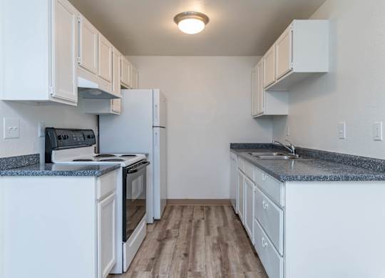 A kitchen with white cabinets and a granite countertop.
