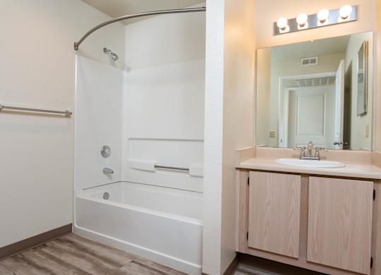 A white bathroom with a walk-in shower and a sink.