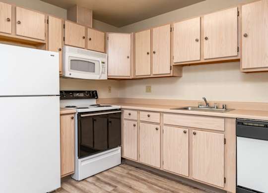 A kitchen with wooden cabinets and white appliances.