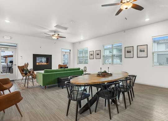 A living room with a fireplace, a couch, a chair, and a dining table.