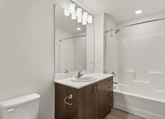 A modern bathroom with a white sink and a mirror above it.