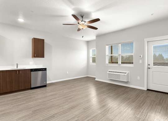 A spacious room with a ceiling fan and a dishwasher.