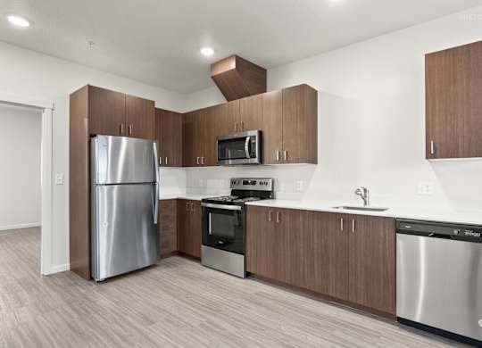 A modern kitchen with a stainless steel refrigerator, microwave, oven, and dishwasher.