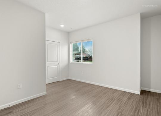 A room with a door and a window with blinds.