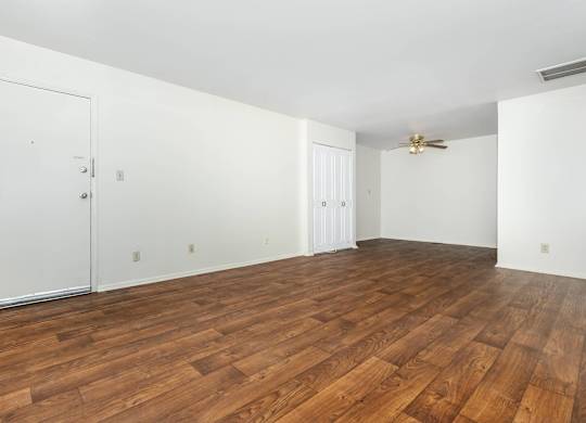 A room with wooden flooring and white walls.