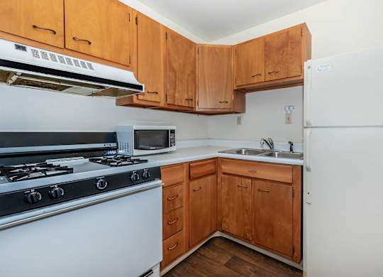 A kitchen with wooden cabinets and a white refrigerator.