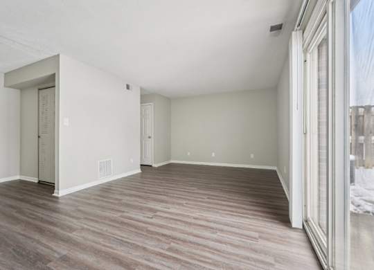 A room with wood flooring and white walls.