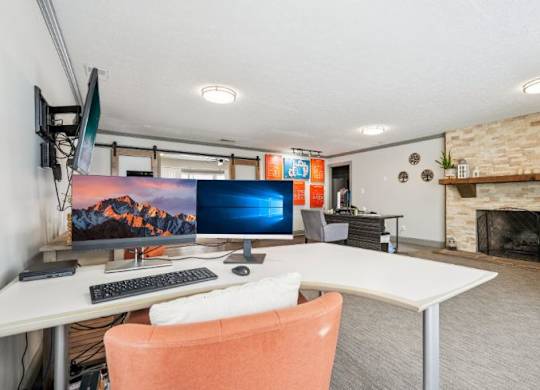 A room with a desk, chair, and a fireplace.