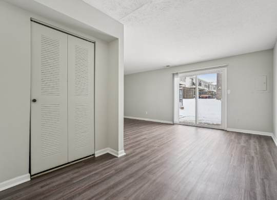 A room with a sliding door and wood flooring.