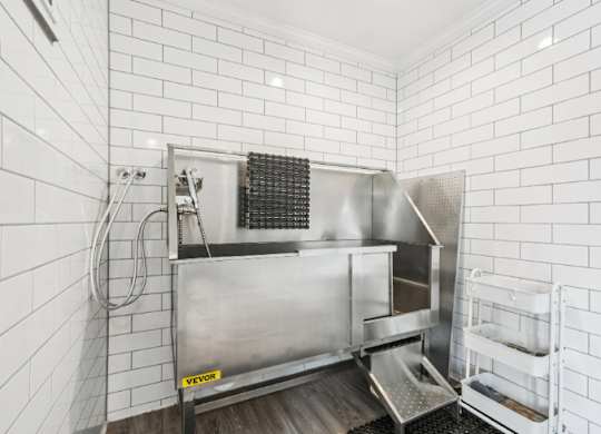 A stainless steel kitchen sink with a drainboard and a dish rack.
