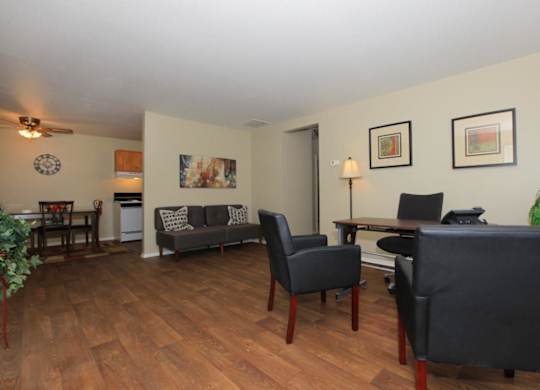 A living room with a grey couch and a wooden floor.