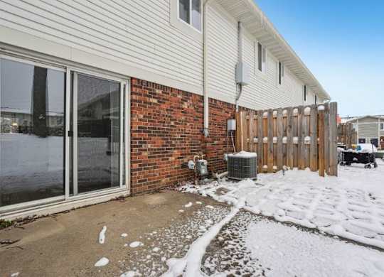 A house with a snow-covered ground in front.