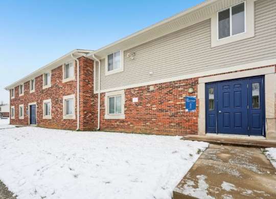 A building with a blue door and windows covered in snow.