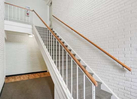 A staircase with white railings and wooden handrails.