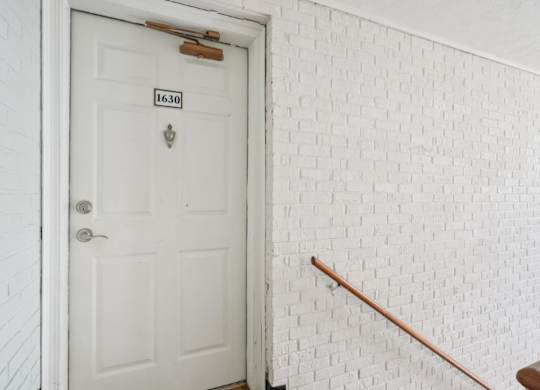 A white door with a number plate on it.
