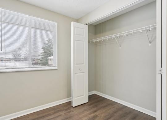 A room with a white door and a window with blinds.