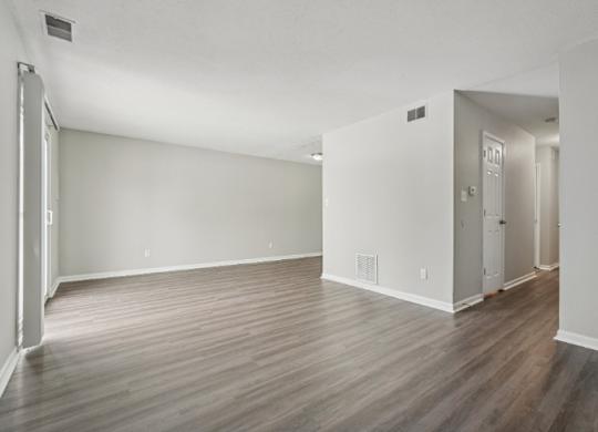 A room with wooden flooring and white walls.