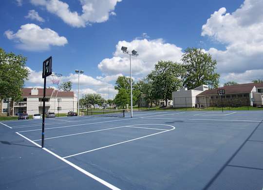 A basketball court with a basketball hoop and a sign on the side.