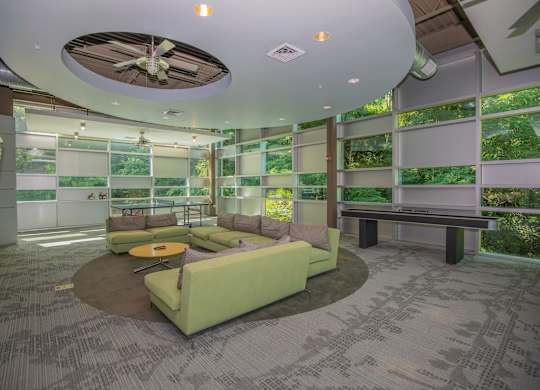 A room with a green couch and a ceiling fan.