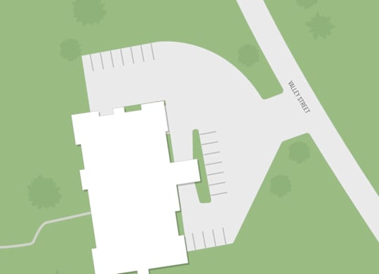 A white building is situated on a green field.