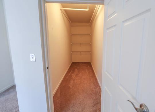 A hallway with a white door and a carpeted floor.