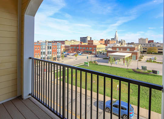 A balcony view of a city street with cars and buildings.