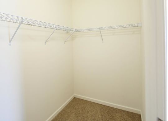 Empty room with a white wall and a white shelf.