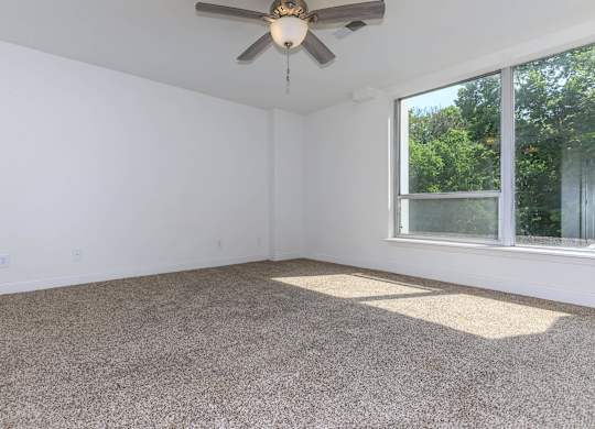 A room with a ceiling fan and a window.