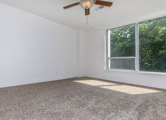 A room with a ceiling fan and a window.
