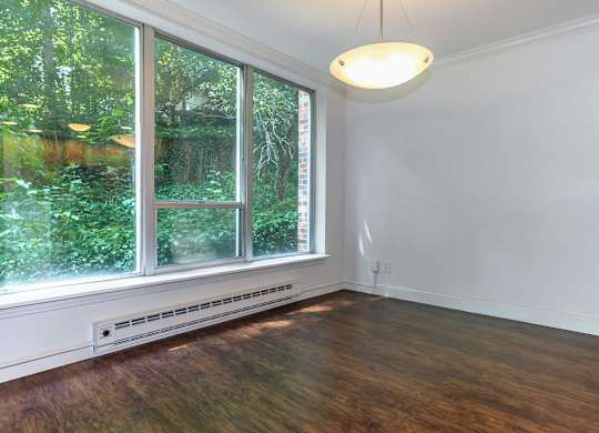 A room with a window and a light hanging from the ceiling.