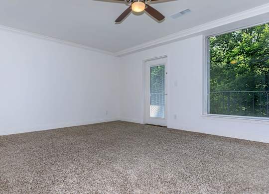 A room with a ceiling fan and carpeted floor.