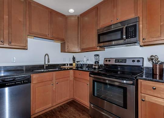 A kitchen with wooden cabinets and black appliances.