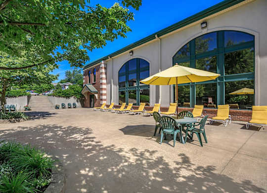 A sunny day at a cafe with tables and chairs under umbrellas.