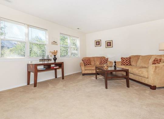 A living room with a couch, two chairs, and a coffee table.