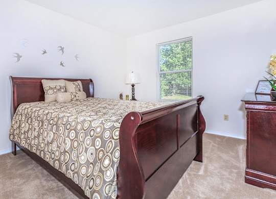 A bedroom with a large bed and a window.