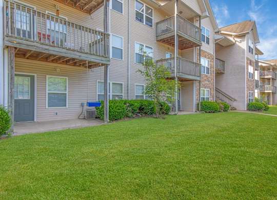 Apartment complex with green grass in front.