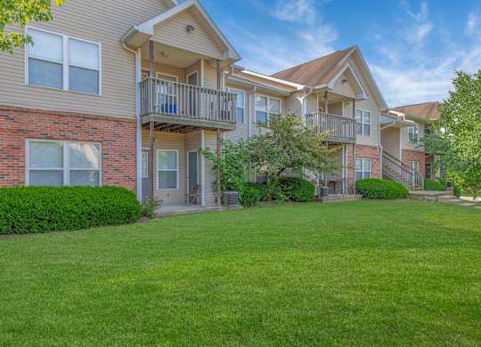 A large grassy area in front of apartment buildings.