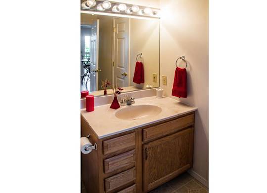 A bathroom with a sink, mirror, and towel rack.