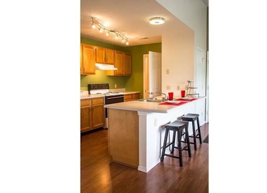 A kitchen with wooden cabinets and a white island.