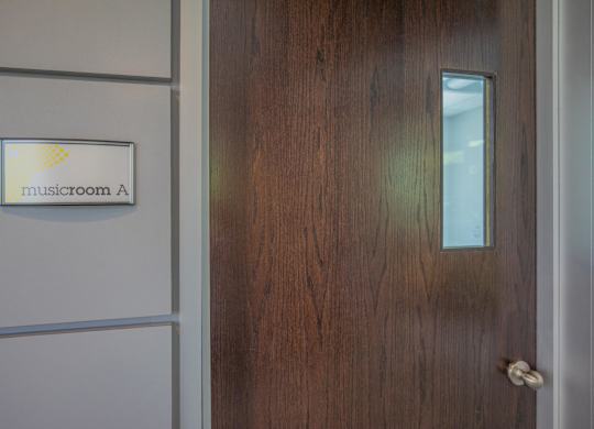 A door with a glass window and a sign that says Musicroom A.
