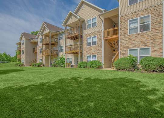 A large grassy area in front of apartment buildings.