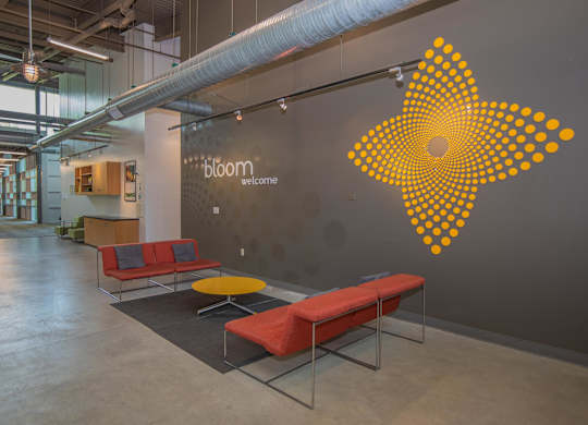 A bloom welcome sign on a wall in a modern office.