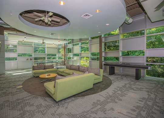 A room with a green couch and a ceiling fan.