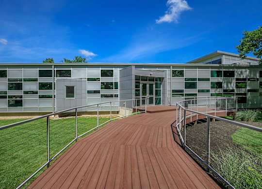A modern building with a wooden walkway leading to the entrance.