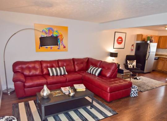 A red leather couch with a coffee table in front of it.