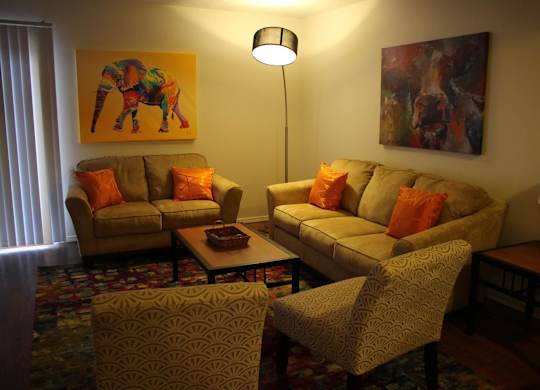 A living room with two couches, a coffee table, and two chairs.