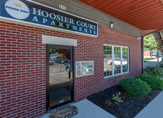 The front of the Hoosier Court Apartments building with a sign that says "Open".