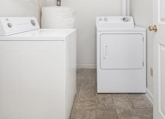 A white washing machine and dryer in a small laundry room.
